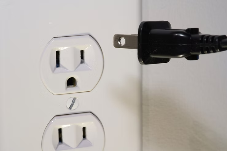 Electrical outlet with plugged cord, illustrating home electrical safety checklist.