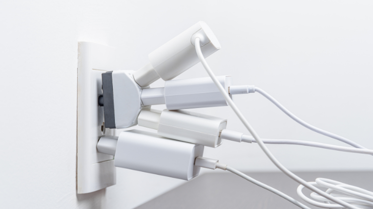 Overloaded electrical outlet with multiple plugs illustrating potential circuit overload in Snohomish homes.