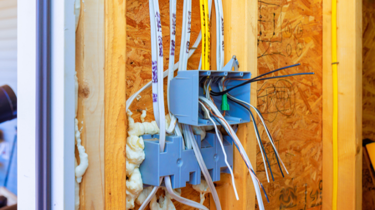 Modern electrical wiring installation in wall cavity during whole home rewiring project.