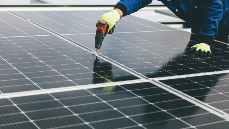 Technician installing solar panels for home backup power systems.