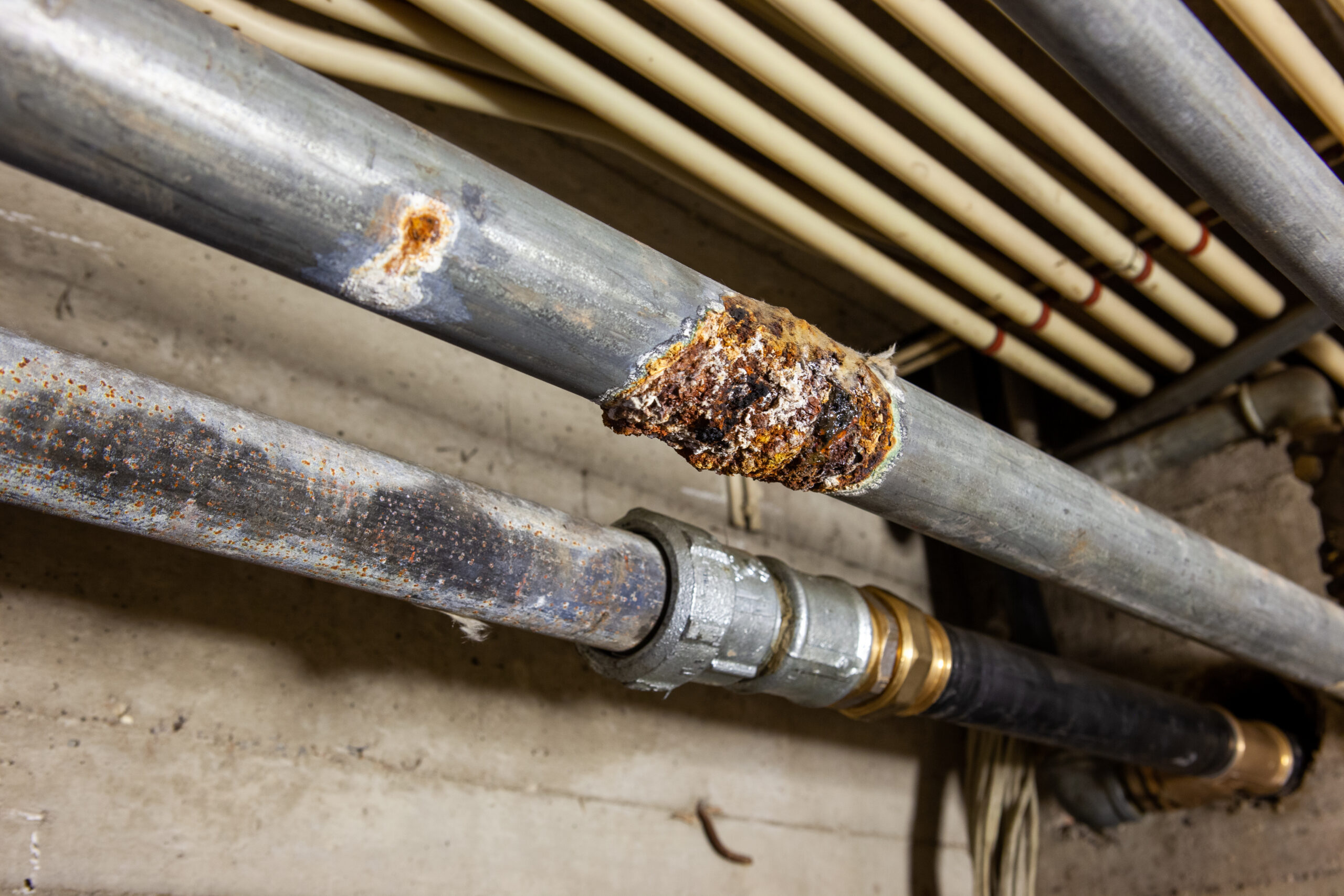 Corroded galvanized pipe fitting with heavy rust buildup at the joint